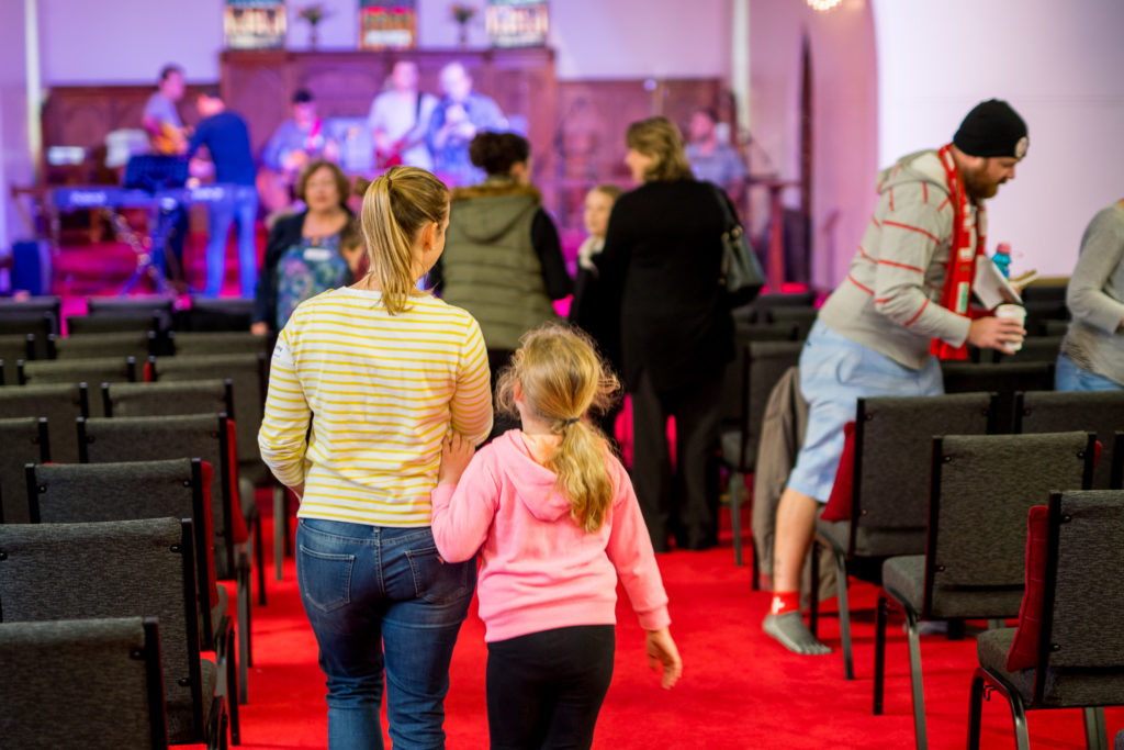 mother with daughter walking in church